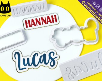 May include: Set of five white plastic cookie cutters, featuring the names "Hannah", "Lucas", and "Lily" in different styles. The cutters are dishwasher safe and customizable.