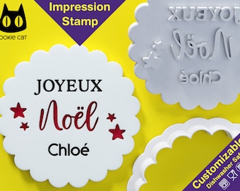 May include: A white, scalloped-edge impression stamp with the words "JOYEUX Noël Chloé" and star cutouts. The stamp is next to a reverse image of the same design and a scalloped cookie cutter. The image also includes the text "Impression Stamp" and "Customizable Dishwasher Safe".