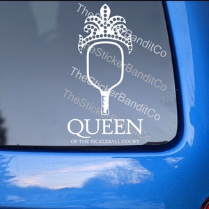 May include: White vinyl decal of a pickleball paddle with a crown on top. The text "QUEEN OF THE PICKLEBALL COURT" is below the paddle.