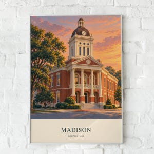 May include: A framed art print featuring a red brick courthouse with a central clock tower under a sunset sky. The building has white columns and a grand entrance. Below the image, the text reads MADISON GEORGIA, USA in black font.