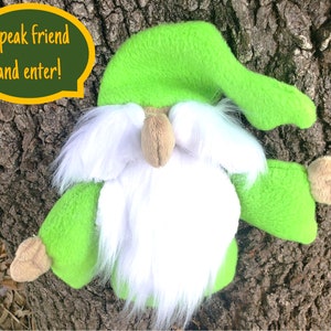 May include: A green plush gnome with a white beard and a green hat. The gnome is holding out its right hand and has a speech bubble above its head that says "Speak friend and enter!"