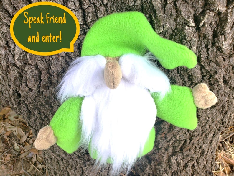 May include: A green plush gnome with a white beard and a green hat. The gnome is holding out its right hand and has a speech bubble above its head that says "Speak friend and enter!"