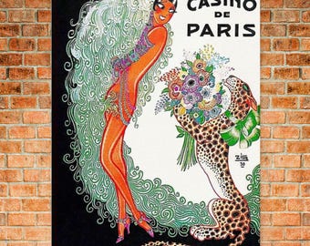 May include: Vintage metal sign with a retro illustration. It shows a woman in an orange dress and a leopard, with the text "CASINO DE PARIS". The artwork has a black and white background with green and purple accents. The sign is mounted on a brick wall.