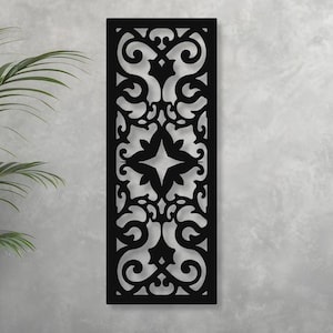 May include: Black rectangular wall art with an intricate, symmetrical cutout design. The pattern features swirling shapes, floral elements, and a central star-like motif. The artwork is mounted on a light gray wall, creating a striking contrast.