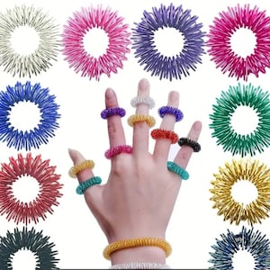 May include: Set of 10 colorful finger and wrist rings made of metal. The rings are designed with a series of interlocking loops that can be manipulated and stretched.