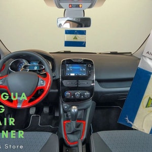 Puede incluir: Un ambientador de coche blanco con la bandera de Nicaragua impresa en él. El ambientador está colgado del espejo retrovisor de un coche. El embalaje dice "Expo Designs Air Fresheners".