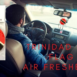 May include: A car air freshener featuring the flag of Trinidad and Tobago. The air freshener is hanging from the rear-view mirror of a car. The text "TRINIDAD CAR FLAG AIR FRESHENER" is written in red letters on the image.