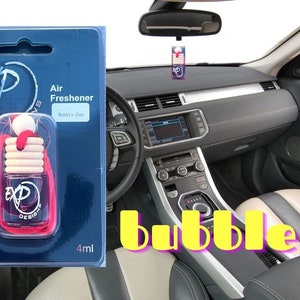 Op de afbeelding: Een rode en witte autoluchtverfrisser met een touwtje eraan. De luchtverfrisser is gelabeld met "EXP Design" en "Air Freshener Bubble Gum". De luchtverfrisser is verpakt in een doorzichtige plastic zak met een blauw en wit etiket. Het etiket zegt "Lasts 45 Days" en "4 ml".