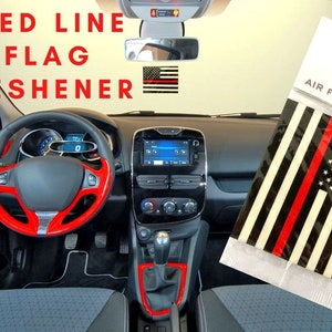 May include: An air freshener with a thin red line design, resembling a flag, is displayed inside a car. The car's interior features red accents on the steering wheel and dashboard. The packaging reads "EXP DESIGNS AIR FRESHENERS."