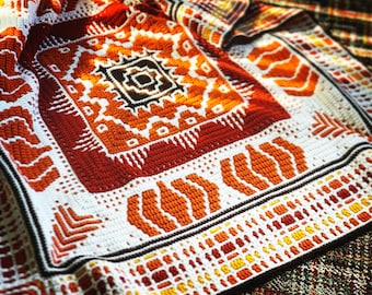 May include: A crocheted blanket with a geometric pattern in shades of orange, red, and white.