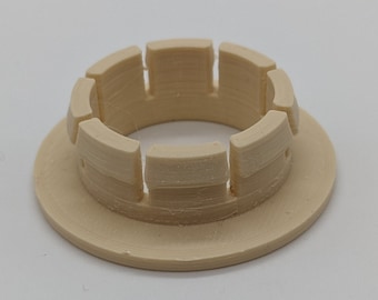 May include: A beige plastic ring with a series of ridges around the outer edge. The ring has a smooth, flat base.