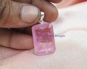May include: A rectangular pink gemstone pendant with a silver-colored bail. The gemstone has a translucent appearance and is set in a silver frame. The text "maliram designs" is visible on the pendant.