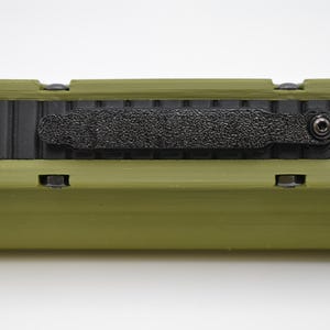 May include: A green and black rectangular case with a black strap and a small screw on the side.