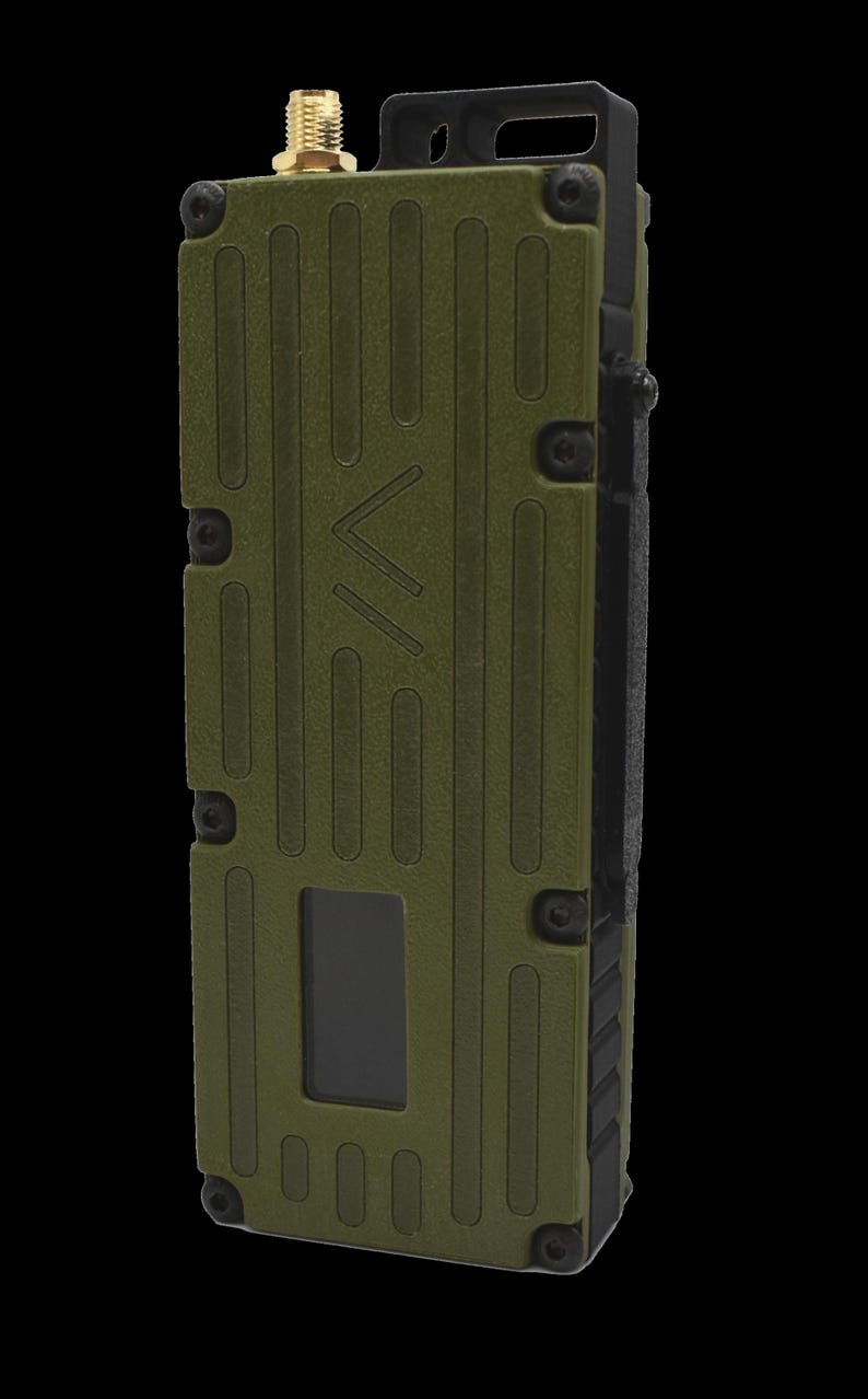 May include: A green, rectangular, handheld radio with a black antenna and a small screen. The radio has a textured surface and a black strap.