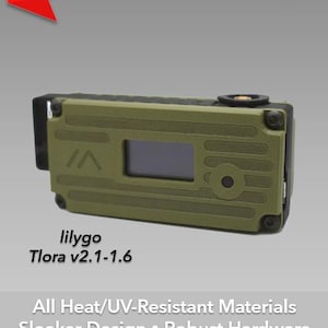 May include: A green and black case for a Lilygo Tlora v2.1-1.6 device. The case is laser engraved with a design that includes a small screen and a button. The text "Generation 2 Laser-Engraved Cases for Meshtastic TM" is at the top of the image. The text "All Heat/UV-Resistant Materials Sleeker Design. Robust Hardware GPS Support. +more!" is at the bottom of the image. The text "QuantumShadow3D QS3D" is at the bottom right of the image.