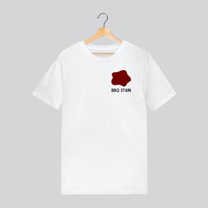 Puede incluir: Camiseta blanca con un diseño de salpicaduras rojas y el texto "BBQ Stain" impreso en la parte delantera.