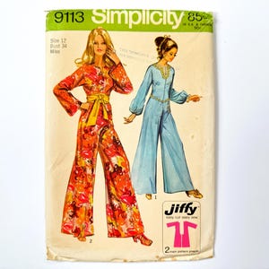 May include: Vintage Simplicity sewing pattern 9113. The pattern features two jumpsuit designs. One jumpsuit is a vibrant floral print with a yellow belt, and the other is a solid light blue colour. The pattern is size 12, bust 86 cm.
