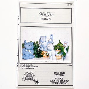 May include: A craft pattern for making three blue cat figurines. The pattern is called "Muffin Pattern" and is from Bee Hive Designs. The pattern includes instructions for making a 10-inch tall sitting cat, a 12 1/2-inch long Kleenex box, and a 12 1/2-inch long planter.
