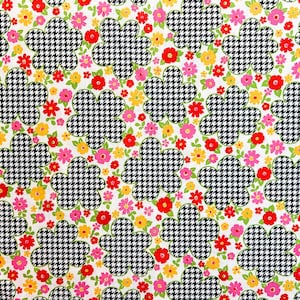May include: A white fabric with a repeating pattern of black and white houndstooth flowers and pink, red, and yellow flowers.