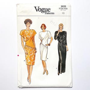Op de afbeelding: Vogue Patterns naaipatroon envelop met illustraties van drie jurken. De witte envelop toont het Vogue-logo en patroongegevens. De jurken omvatten een gele jurk met bloemenprint, een witte jurk en een zwarte jurk met pailletten.