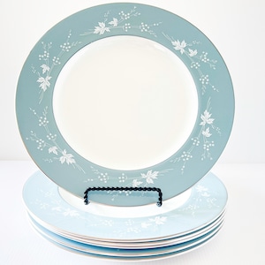 Pode incluir: Conjunto de seis pratos de jantar azuis e brancos com um design floral. Os pratos estão empilhados uns sobre os outros.