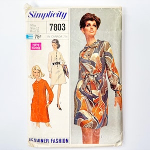 May include: Simplicity sewing pattern number 7803 for a dress. The pattern includes three different dress styles: a white dress with a collar, a red dress with a collar, and a multi-colored dress with a collar. The pattern is for sizes 12 and bust 34.
