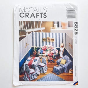 May include: A McCall's Crafts sewing pattern envelope showing a miniature dollhouse interior. The scene includes a floral sofa, table, chairs, and a blue patterned armchair. The text "McCall's Crafts" is at the top.