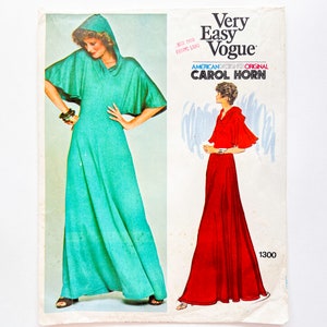 May include: A vintage sewing pattern for a long, flowing dress with a cowl neck and cape sleeves. The pattern is from Very Easy Vogue and is designed by Carol Horn. The pattern number is 1300.