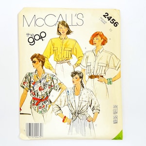 Op de afbeelding: McCall's patroon 2456 voor een shirt, ontworpen voor The Gap. Het patroon toont vier verschillende stijlen shirts, waaronder een geel shirt, een wit shirt, een shirt met een patroon en een wit shirt met een stropdas.
