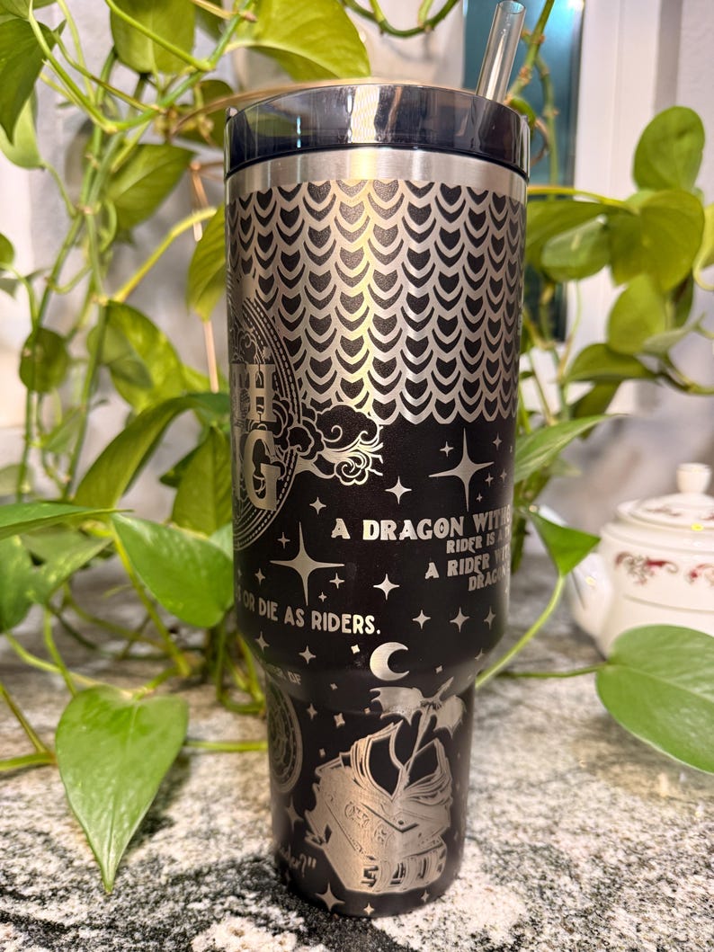 Puede incluir: Vaso de acero inoxidable negro con un dise&ntilde;o de drag&oacute;n plateado y el texto "A dragon without a rider is a rider without a dragon. Or die as riders." Incluye una pajita y una tapa negra.