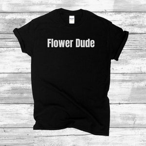 Może przedstawiać: Czarny T-shirt z nadrukiem "Flower Dude" w kolorze białym na przodzie.