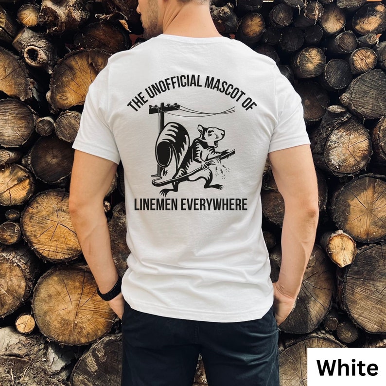 May include: White t-shirt with a black graphic on the back. The graphic features a cartoon rat playing a guitar near a utility pole, with the text "THE UNOFFICIAL MASCOT OF LINEMEN EVERYWHERE".