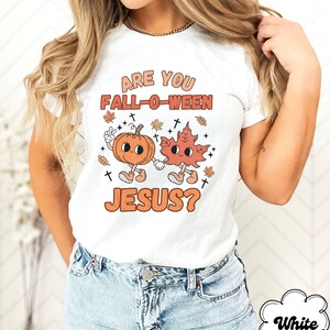 May include: White t-shirt with the text "Are you Fall-o-ween Jesus?"  A cartoon pumpkin and leaf are holding hands.