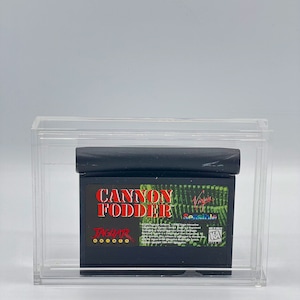 May include: A black Atari Jaguar game cartridge for Cannon Fodder, a video game developed by Sensible Software and published by Virgin Interactive Entertainment. The cartridge is in a clear plastic case.