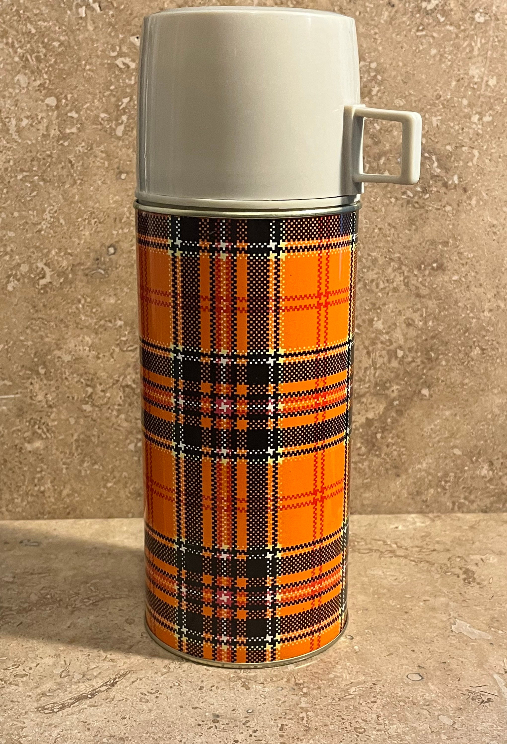 Vintage Thermos An Old Retro Plaid Thermos In The Hands Of A Child