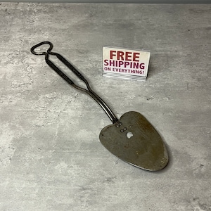 May include: A vintage metal heart-shaped cookie cutter with a handle. The cutter has a small heart-shaped hole in the center.