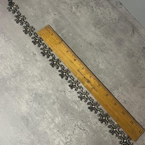 Peut inclure: Un bracelet en argent avec un motif g&eacute;om&eacute;trique r&eacute;p&eacute;titif. Le bracelet mesure environ 18 cm de long.