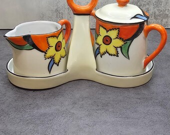 Juego de azucarero y cremera vintage con soporte, diseño floral en naranja y amarillo de mediados de siglo, hecho en Japón.