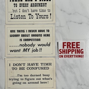 May include: Three vintage-style motivational cards with black text on a white background. The first card reads "There are 2 sides to every argument...but I don't have time to listen to yours!" The second card reads "One thing I never have to worry about around here is competition...nobody would want my job!!" The third card reads "I don't have time to be confused...I'm too darned busy trying to figure out what's going on around here!"