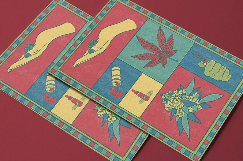 May include: Two square art prints with a red, blue, and yellow color scheme. Each print features a hand, cannabis leaf, lighter, and other related illustrations. The prints have a decorative border and are displayed on a red surface.