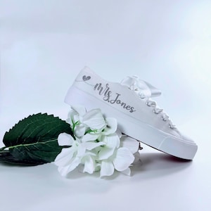 White canvas Bridal sneakers design with a silver glitter heart and the text 'Mrs. last name marriage' on the side.