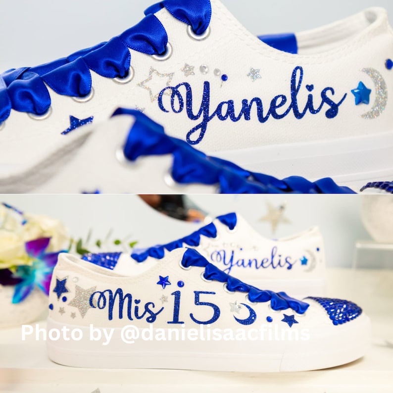 Puede incluir: Zapatillas blancas de lona con cordones de cinta azul y detalles de purpurina plateada. Las zapatillas est&aacute;n decoradas con estrellas, una luna creciente y el texto "Yanelis" y "Mis 15".