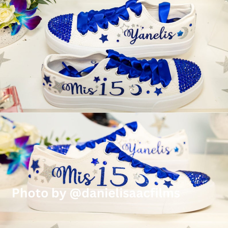 Puede incluir: Zapatillas blancas de lona con cordones de sat&eacute;n azul y pedrer&iacute;a azul. Las zapatillas est&aacute;n decoradas con estrellas plateadas de purpurina y el texto "Mis 15" y "Yanelis".