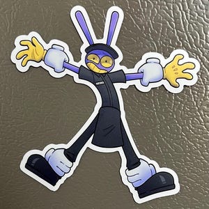 Op de afbeelding: Een sticker met een cartoon konijn karakter met een ondeugende grijns. Het konijn heeft paarse oren, een zwart uniform en gele handen. De sticker staat op een grijze achtergrond.