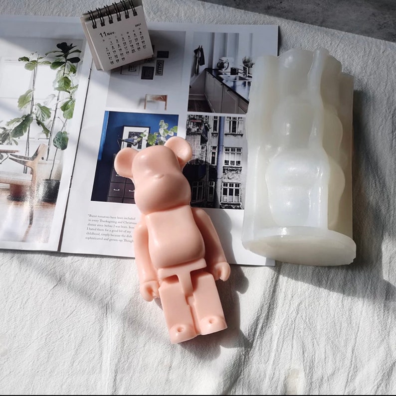 May include: A pink bear-shaped silicone mold and a pink bear-shaped candle. The mold is made of silicone and has a smooth surface. The candle is made of wax and has a matte finish.