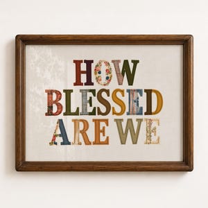 Puede incluir: Una pieza de arte mural enmarcada con el texto HOW BLESSED ARE WE. Cada letra está rellena con varios patrones de tela, incluyendo flores, cuadros y colores sólidos en tonos rojo, verde, azul, marrón y amarillo, sobre un fondo claro.