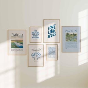 May include: A collection of six framed art prints with various designs and text. The prints feature landscape scenes, floral patterns, and inspirational quotes in blue and white. The frames are a light brown color, and the prints are displayed on a white wall.