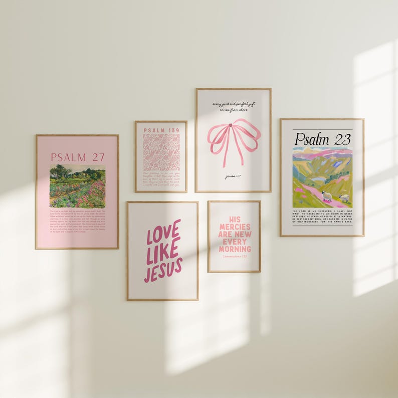 May include: A set of six framed prints with pink and white text and images. The prints feature bible verses, including Psalm 23, Psalm 27, and Psalm 139. The prints are arranged in a grid pattern on a white wall.
