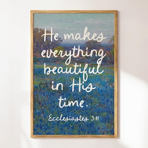 May include: A framed print with a blue and green landscape background. The text "He makes everything beautiful in His time. Ecclesiastes 3:11" is written in white cursive font.