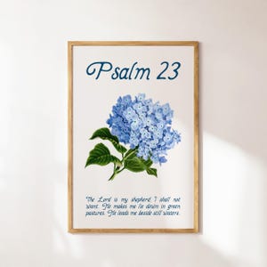 May include: A framed print with a blue hydrangea flower and the text "Psalm 23" in blue lettering. The text below the flower reads "The Lord is my shepherd: I shall not want. He makes me lie down in green pastures. He leads me beside still waters."